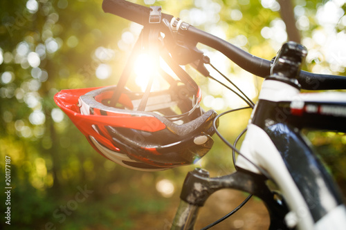 Photo of bicycle with helmet on steering wheel on blurred background