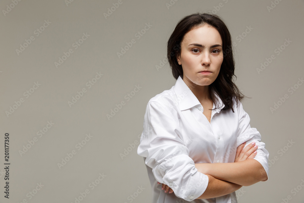 Beautiful girl in a white shirt shows emotions - disorder. On a light background. Beautiful girl in a white shirt shows emotions - disorder. On a light background.