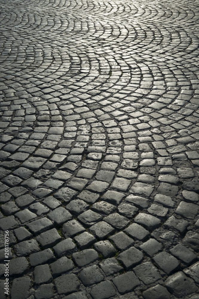 Full frame background of old-fashioned European cobbled plaza laid out in circular pattern in Naples, Italy