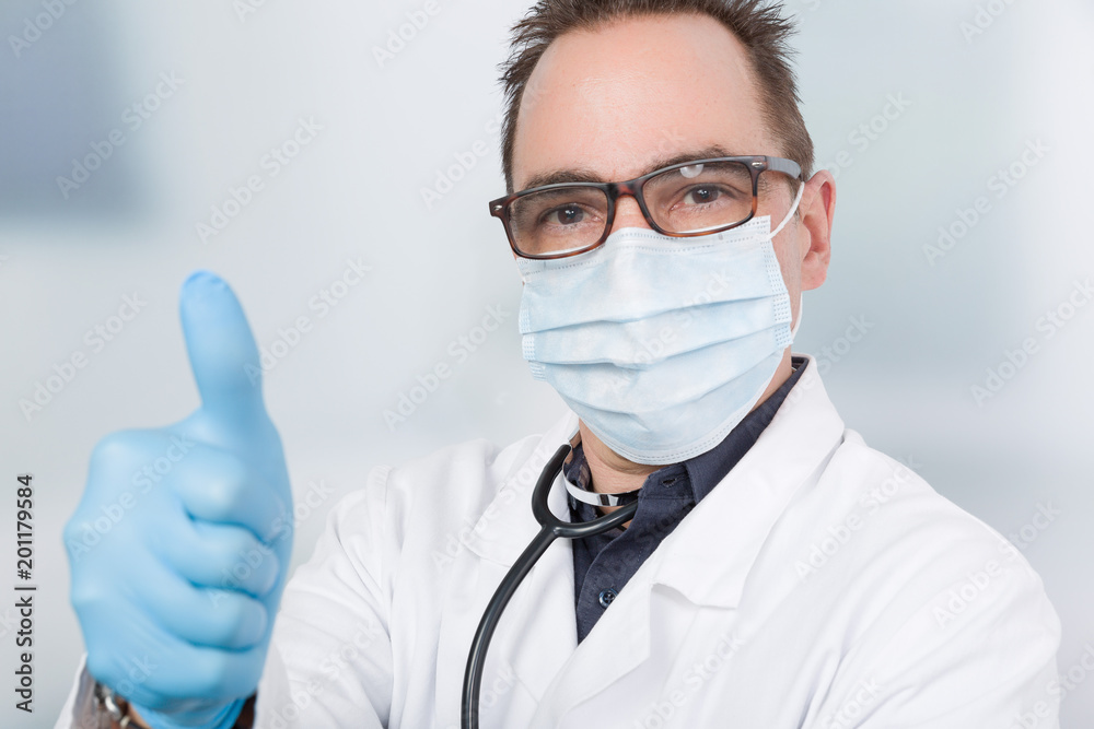 Ein Arzt mit medizinischen Handschuhen zeigt Daumen hoch Ein Arzt mit medizinischen Handschuhen zeigt Daumen hoch