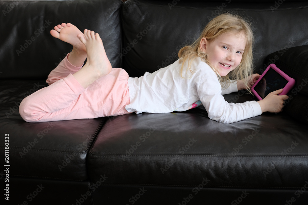 blondes mädchen mit tablet auf dem leder sofa Stock Photo | Adobe Stock