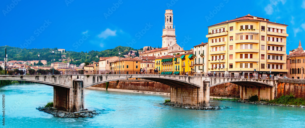 Verona, Italy. Scenery with Adige River and Ponte di Pietra at summer day with blue sky. Panorama. Ancient european Italian city