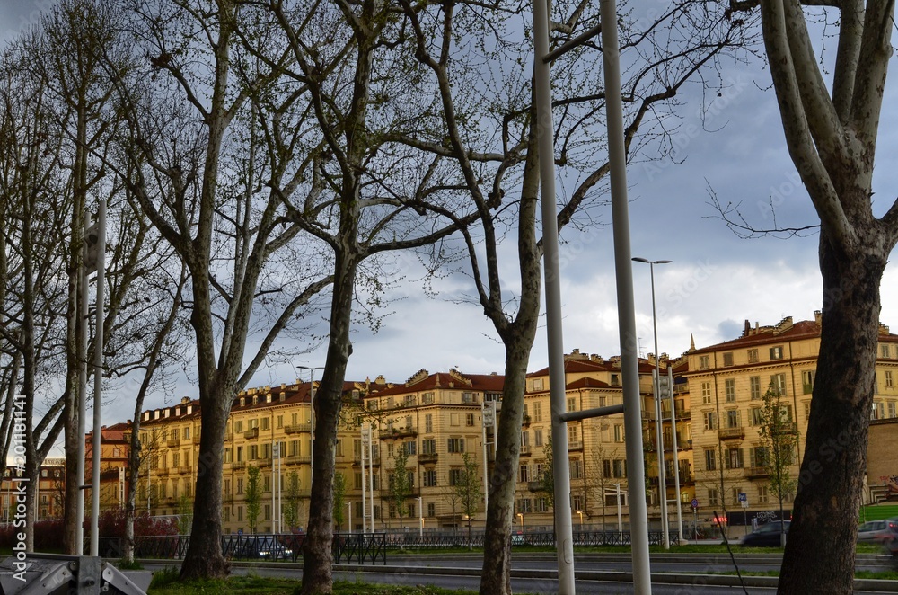 Turin, Piedmont, Italy. April 13 2018. Nearby the Porta Susa railway station, a spring rainy and sunny day gives light-dark effects on the houses of the historic center.