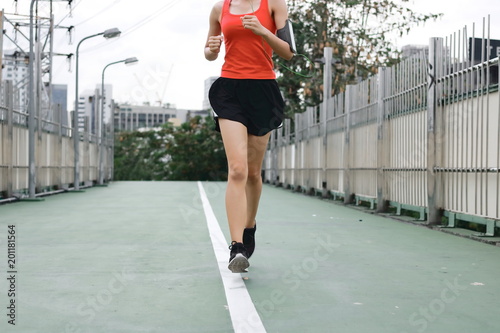 Woman's legs running exercise outdoors. Fitness and wellness concept. © tuaindeed