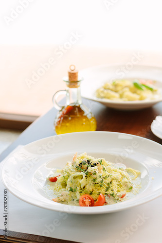 Italian food - fettuccine pasta and pesto sauce with seafood.