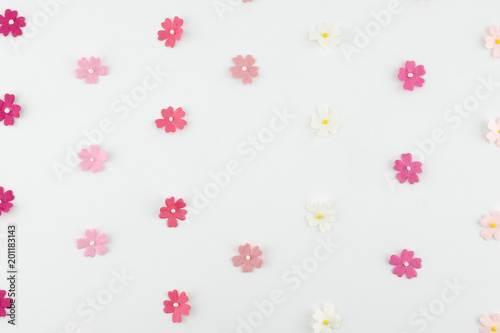 Pink tone paper flowers horizontal pattern on white background with copy space round copy space in center