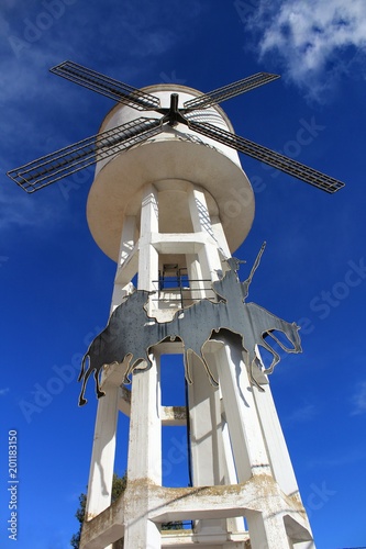 Water tank shaped like a windmill under blue sky photo