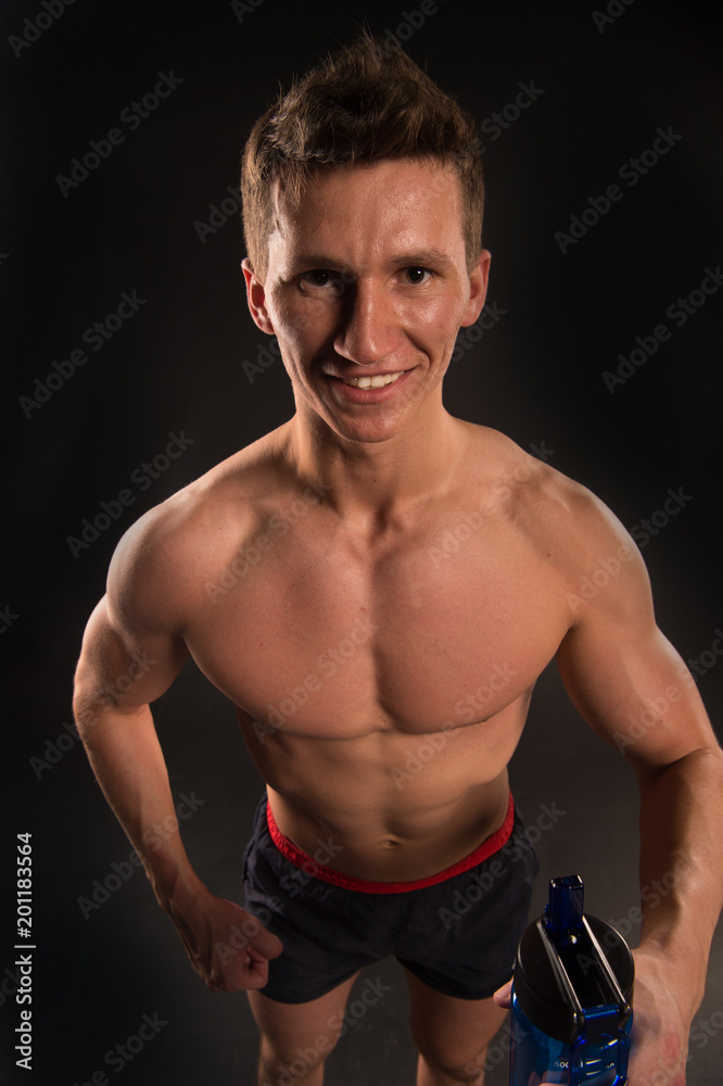 Sportsman smile with sport bottle. Happy man with fit body and torso. Thirsty athlete smiling with bottle of water. Thirst and dehydration concept. Drinking water after training and workout Sportsman smile with sport bottle. Happy man with fit body and torso. Thirsty athlete smiling with bottle of water. Thirst and dehydration concept. Drinking water after training and workout