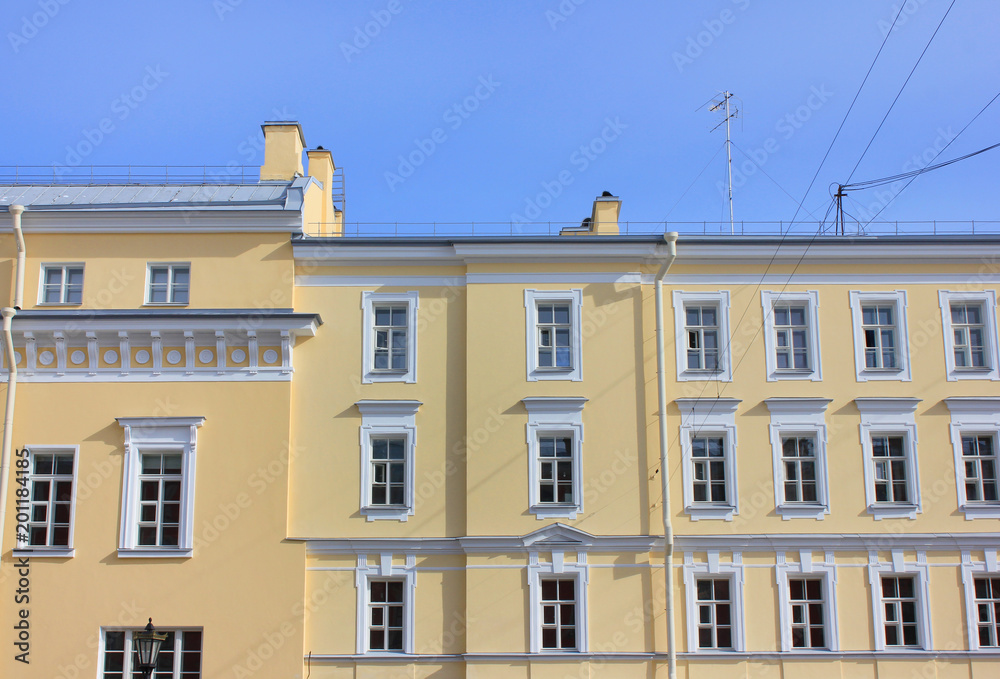 Minimalist Architecture Building Facade of Old Historic House with Soft Yellow Colored Walls. Exterior Design and Elements of Apartment Building Front View. Classic European Style, Basic House View.