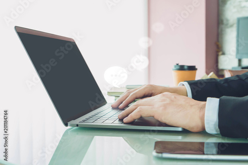 Hand of Businessman typing on laptop with smartphone in home office or co working space.Concept of Live Chat Chatting on Communication Digital Web and Social Application.