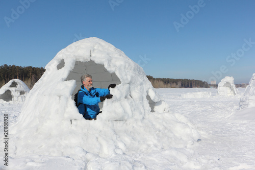 Man building an igloo on a snowy reservoir in winter, Novosibirsk, Russia