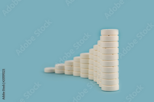 Tablets of white color, laid in columns, the height of which is successively reduced on a blue background.