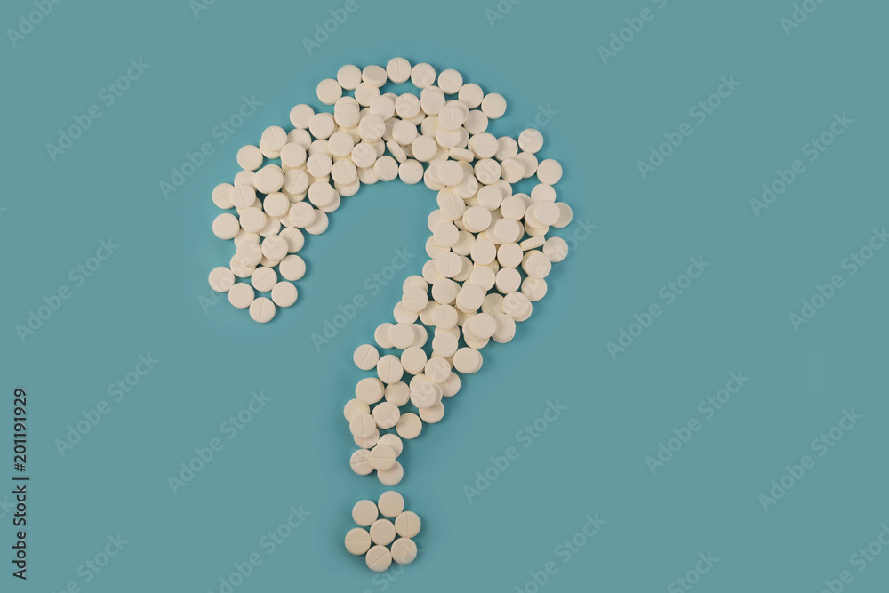 White tablets, laid in the form of a question mark, a question mark with a medical bias. White tablets, laid in the form of a question mark, a question mark with a medical bias.