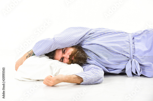Man with sleepy face lies on pillow. Hipster with beard