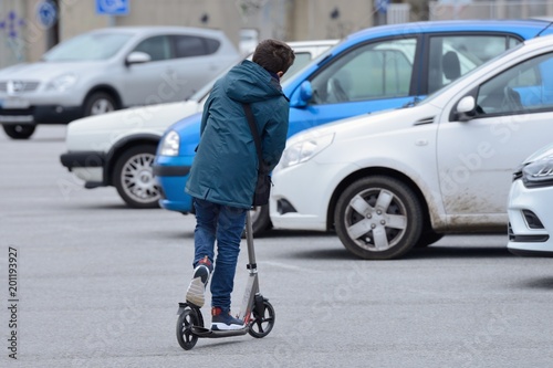 boy riding a scooter on the street