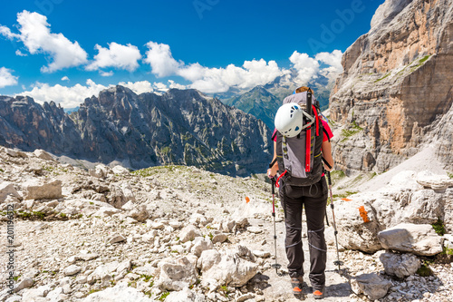 Female trekker walking along mountain valley.