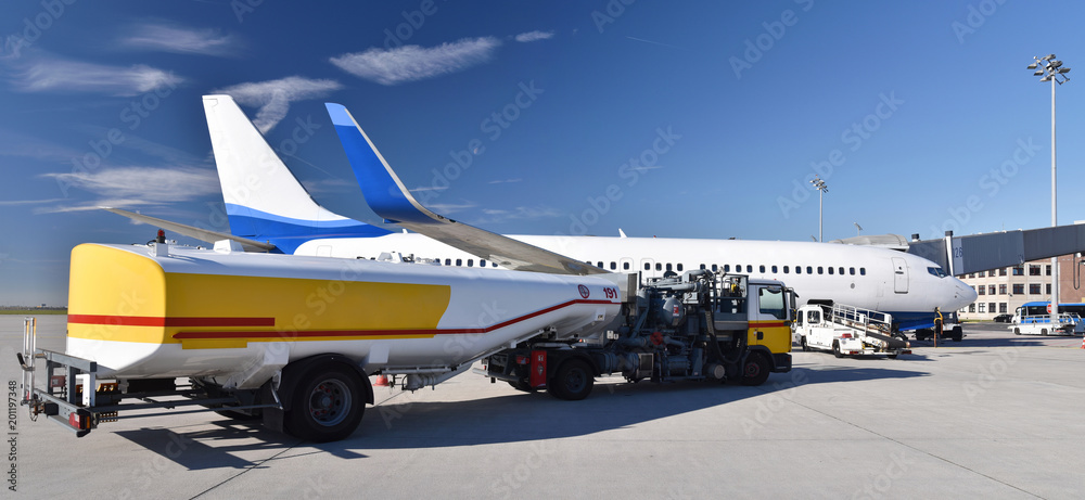Fototapeta premium auftanken eines Flugzeuges am fklughafen mit Kerosin - Abfertigung durch Bodenpersonal // refuelling an aircraft at the airport with kerosene