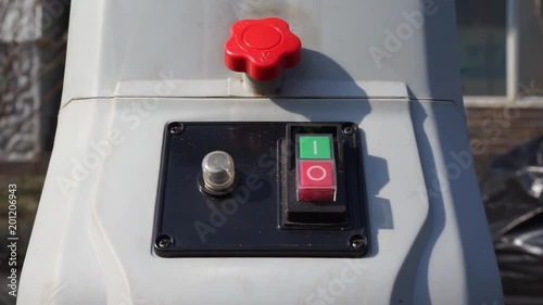 Man with gloves is pushing start/stop engine button