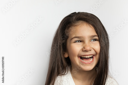 Portrait of happy smiling brunette child girl with long hear isolated on white background. Place for text. © kaganskaya115