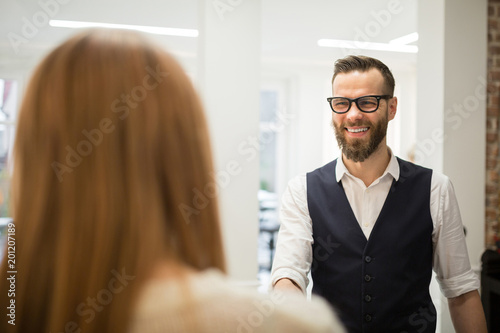 Happy hairdresser greeting customer at door © innervisionpro