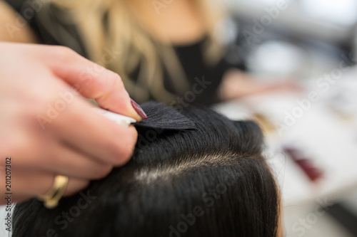 Hairdresser hand putting hair color sample to client head © innervisionpro