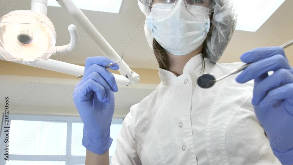Dentist at work in dental clinic, during visit of client. Patient point of view