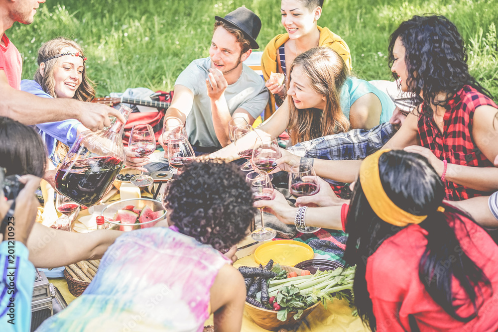 Group of happy friends enjoying picnic while drinking red wine and eating snack appetizers outdoor Group of happy friends enjoying picnic while drinking red wine and eating snack appetizers outdoor