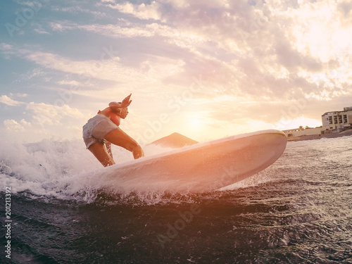 Photography Fit female athlete surfing at sunset