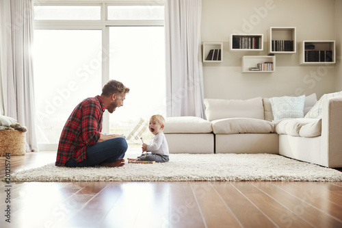 Quadro su tela Young father and son playing together in their sitting room