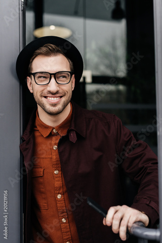 cheerful stylish man in eyeglasses and trendy hat