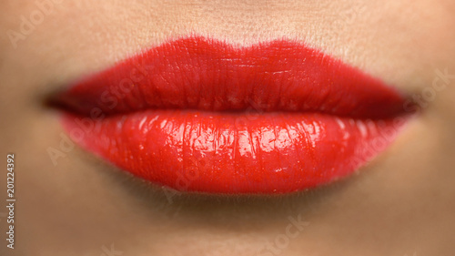 beauty, make up and people concept - close up of woman lips or mouth with red lipstick