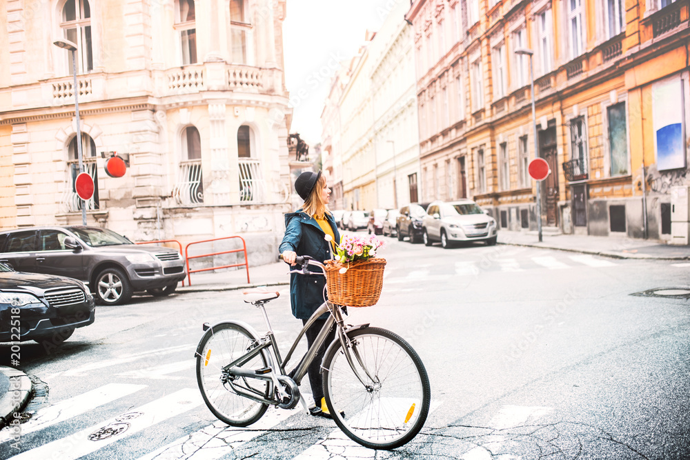 Young woman with bicycle in sunny spring town. Young woman with bicycle in sunny spring town.