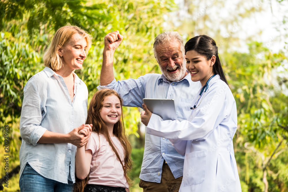 Doctor with family patients talking about medical consultation in a park. Healthcare concept