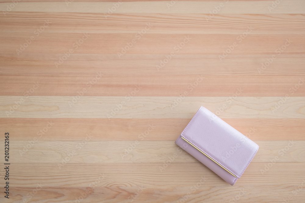 pink clutch purse lies on a flat wooden surface. Women's accessories. Fashionable style. Flat lay. pink clutch purse lies on a flat wooden surface. Women's accessories. Fashionable style. Flat lay.