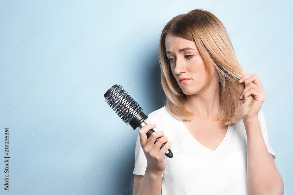 Young woman with hair loss problem on color background Young woman with hair loss problem on color background
