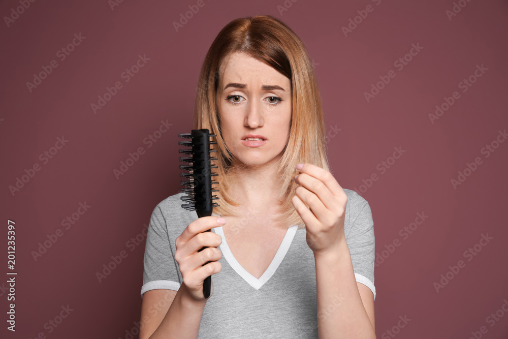 Young woman with hair loss problem on color background Young woman with hair loss problem on color background