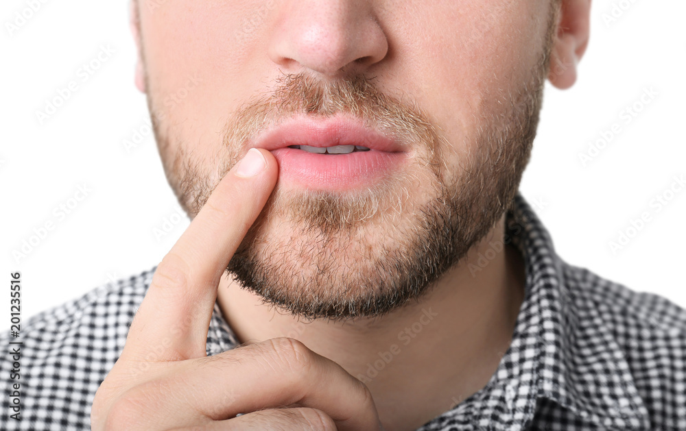 Obraz premium Young man touching lips against white background, closeup