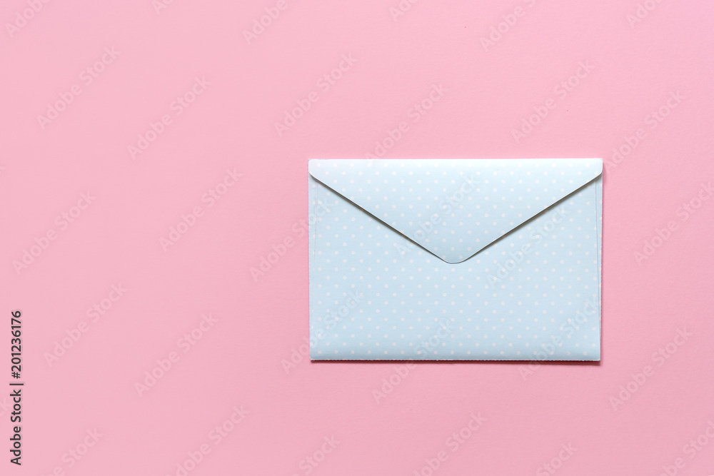 blue envelope in white peas on a pink background blue envelope in white peas on a pink background