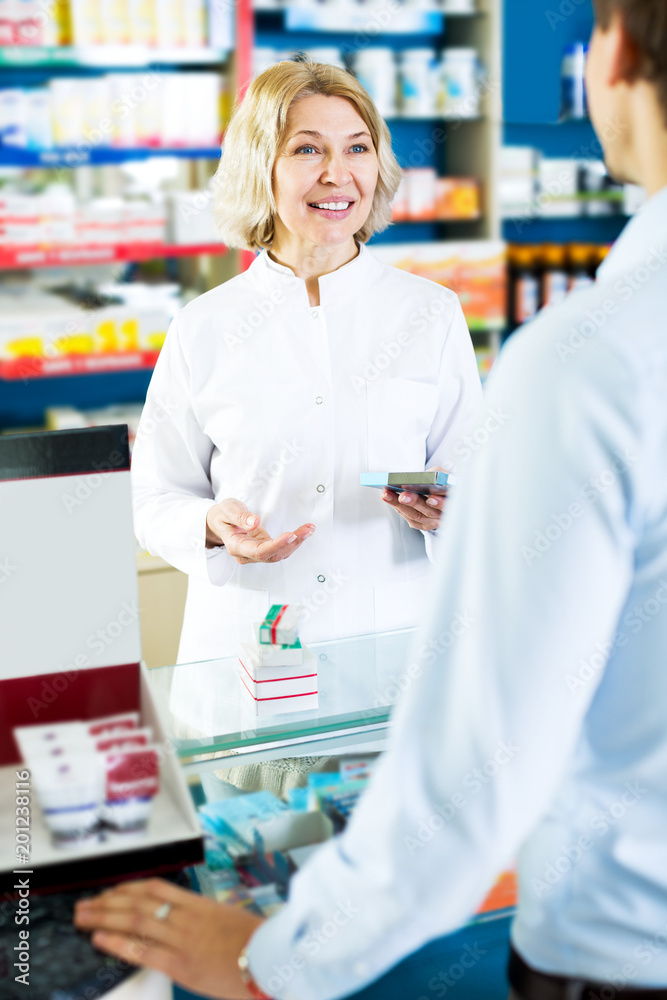 Helpful pharmacist serving and consulting man