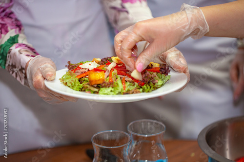 chef decorates the salad with greens © Volodymyr Shcerbak