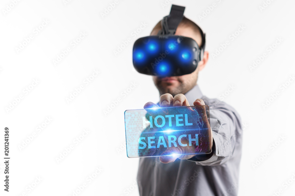 Business, Technology, Internet and network concept. Young businessman working in virtual reality glasses sees the inscription: Hotel search Business, Technology, Internet and network concept. Young businessman working in virtual reality glasses sees the inscription: Hotel search