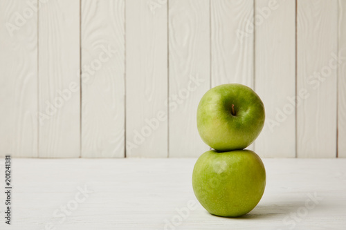 Two raw fresh green apples on wooden background with copy space