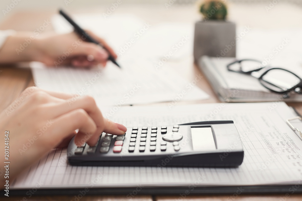 Closeup of woman hand counting on calculator Closeup of woman hand counting on calculator