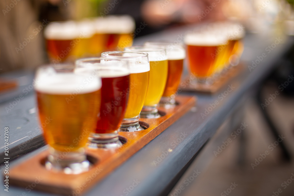 Line of beers on wooden table in a beer garden Line of beers on wooden table in a beer garden