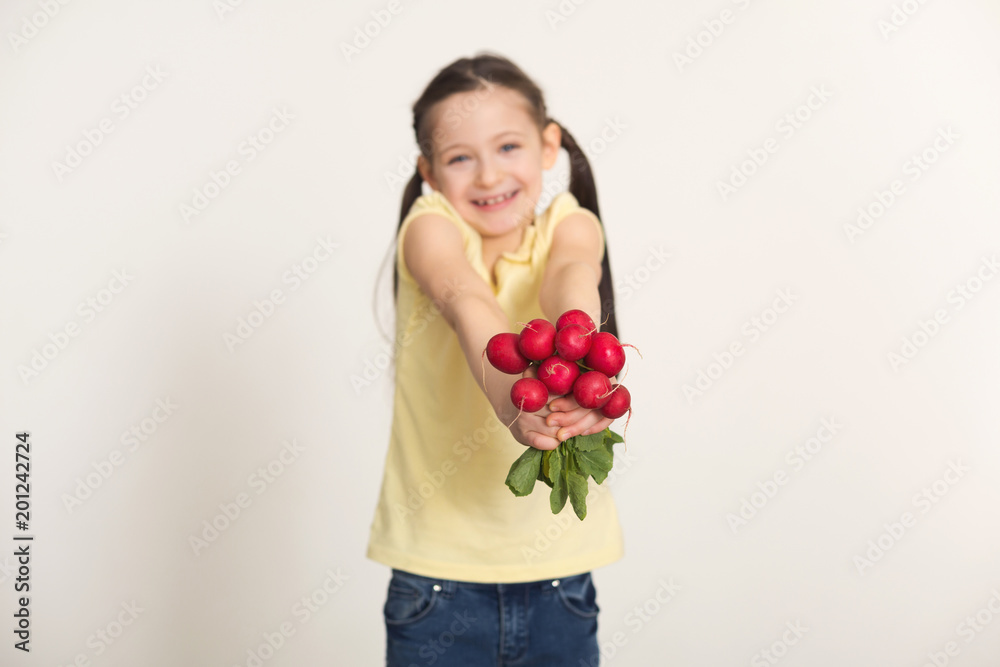 Happy little girl with radish over white background Happy little girl with radish over white background