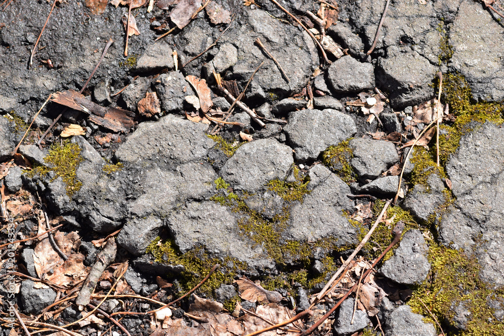 Broken and crumbling asphalt closeup abstract texture background. 