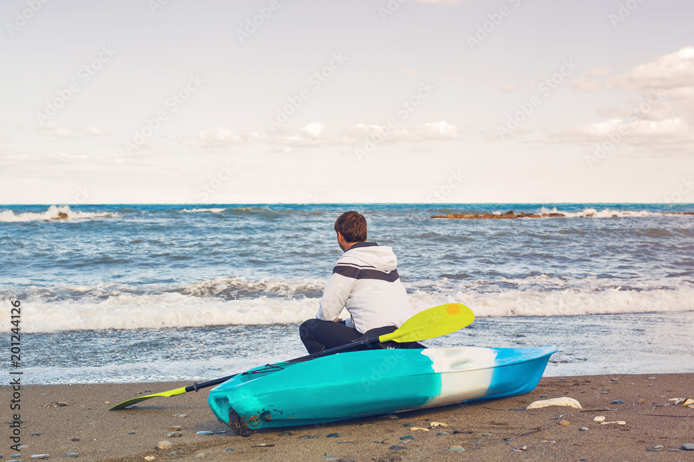 man sitting on kayak at sea beach man sitting on kayak at sea beach