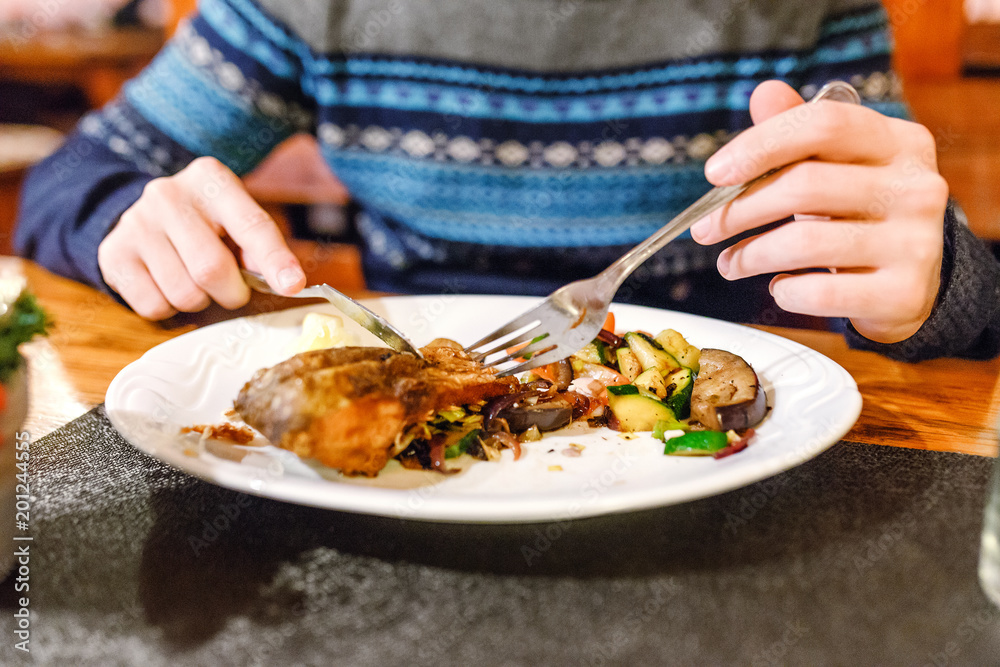 Handsome man eating christmas czech cuisine grilled or fried carp fish in restaurant