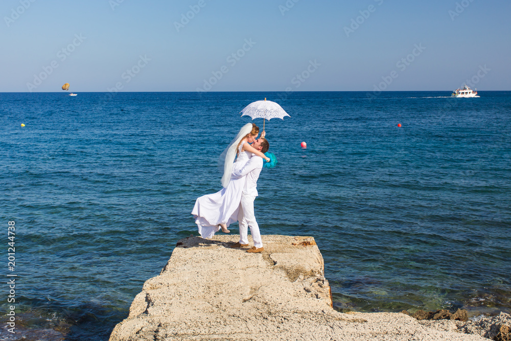 Bride and groom by the sea on their wedding day Bride and groom by the sea on their wedding day
