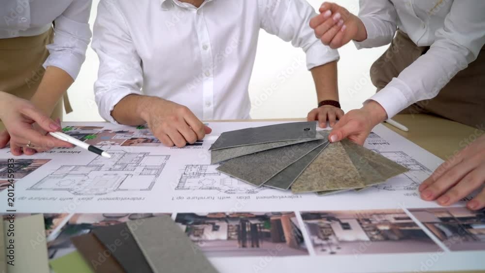 Close up of hands of architects holding color chart. designers architects team project working on desk close up 4 k Choice from palette color scale, hand pointing blueprint  decorators drawing
